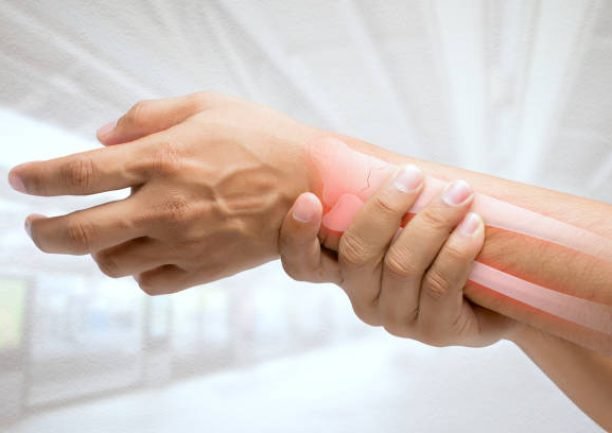 Man massaging painful wrist on a white background. Pain concept